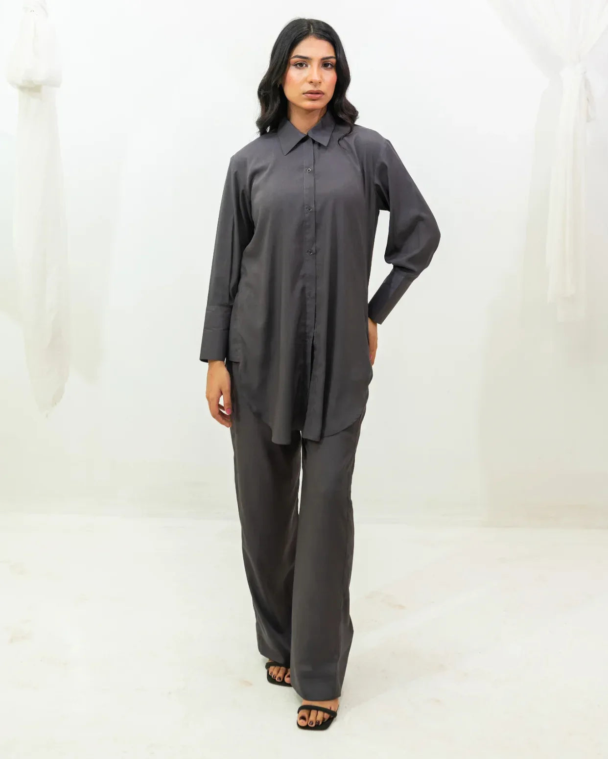 Woman wearing a charcoal gray outfit on a white background