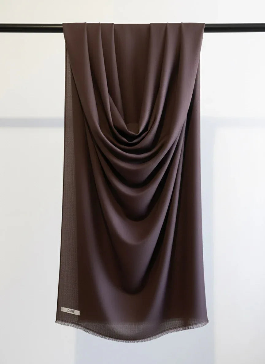 Dark Brown scarf draped over a black rod against a white background