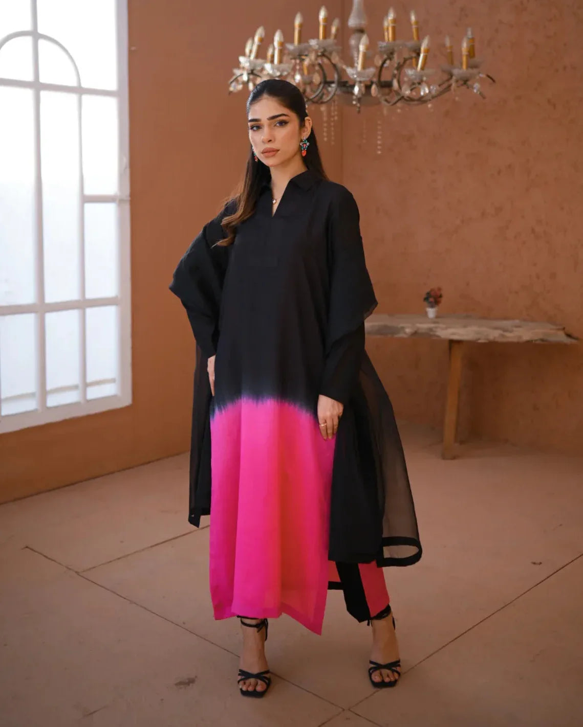 A woman wearing a three piece rawsilk dress with an ombre shirt and trousers, and an organza dupatta.