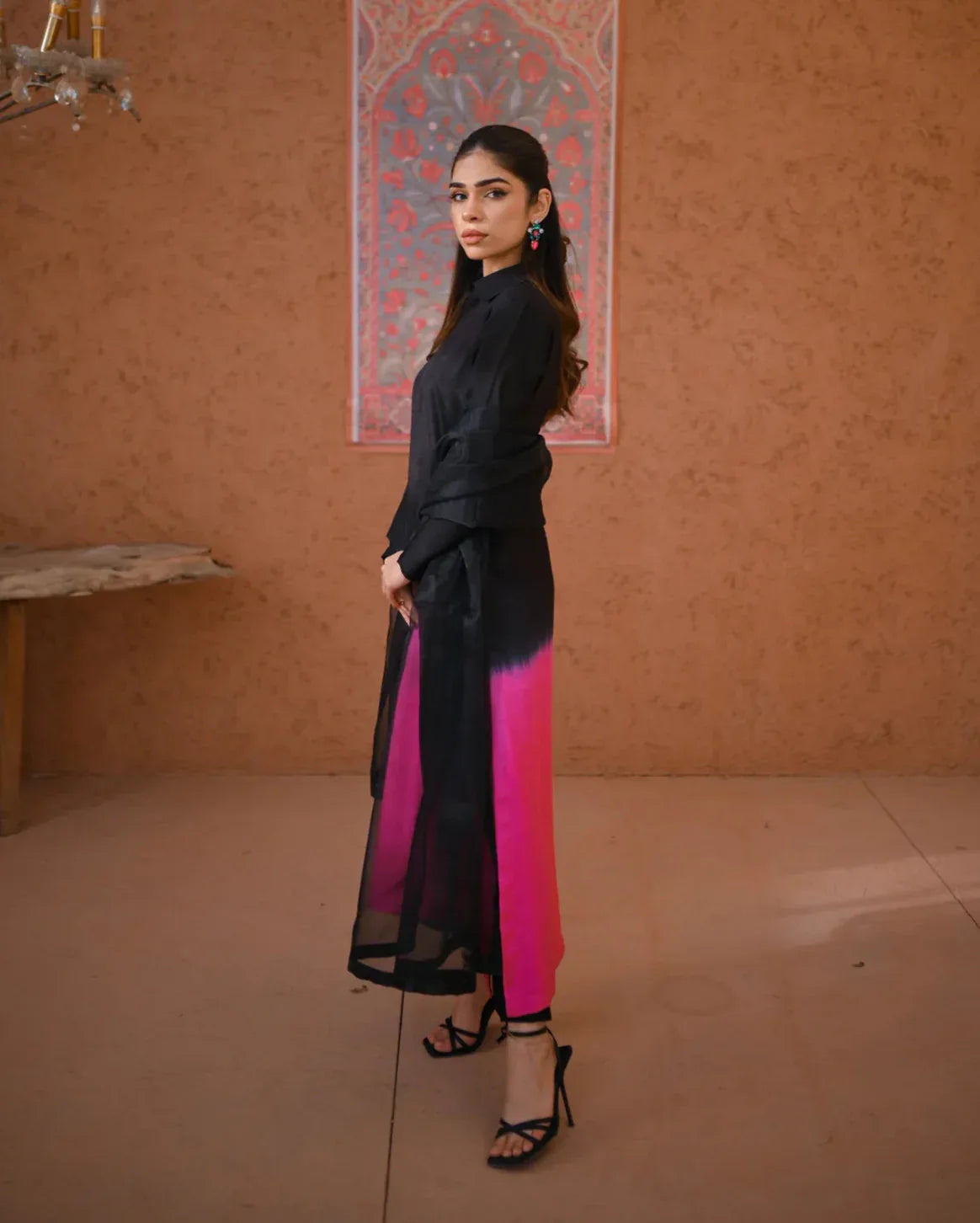 A woman wearing a three piece rawsilk dress with an ombre shirt and trousers, and an organza dupatta.