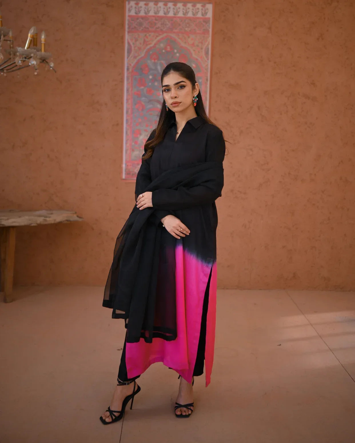 A woman wearing a three piece rawsilk dress with an ombre shirt and trousers, and an organza dupatta.