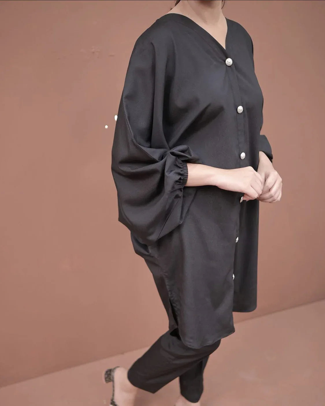 A women wearing a two piece charcoal black dress.