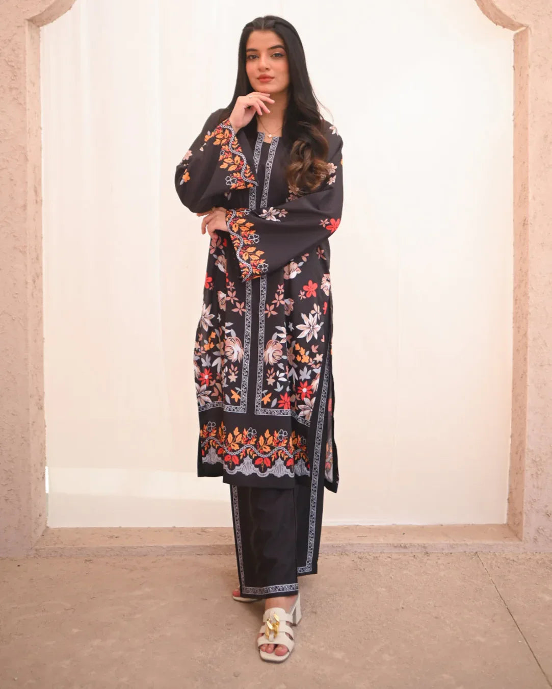 Women wearing a printed black two piece dress which includes a shirt and culotte.