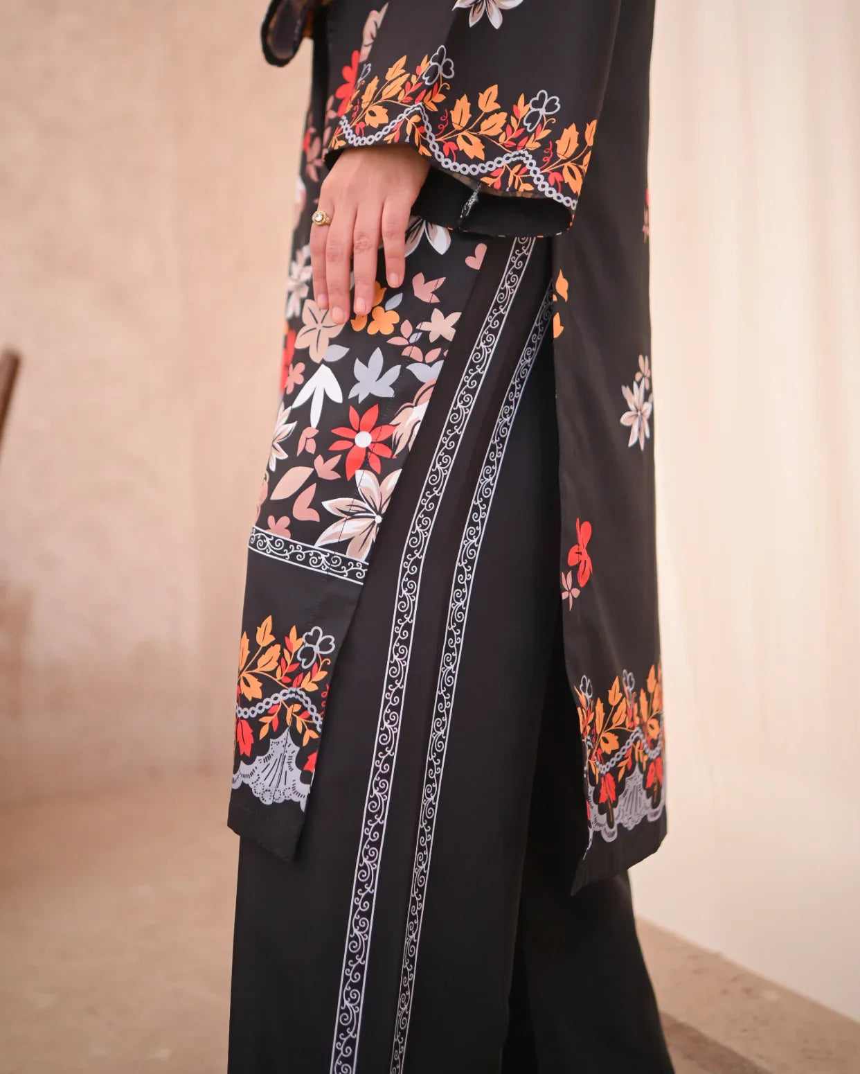close up on the details of Women wearing a printed black two piece dress.
