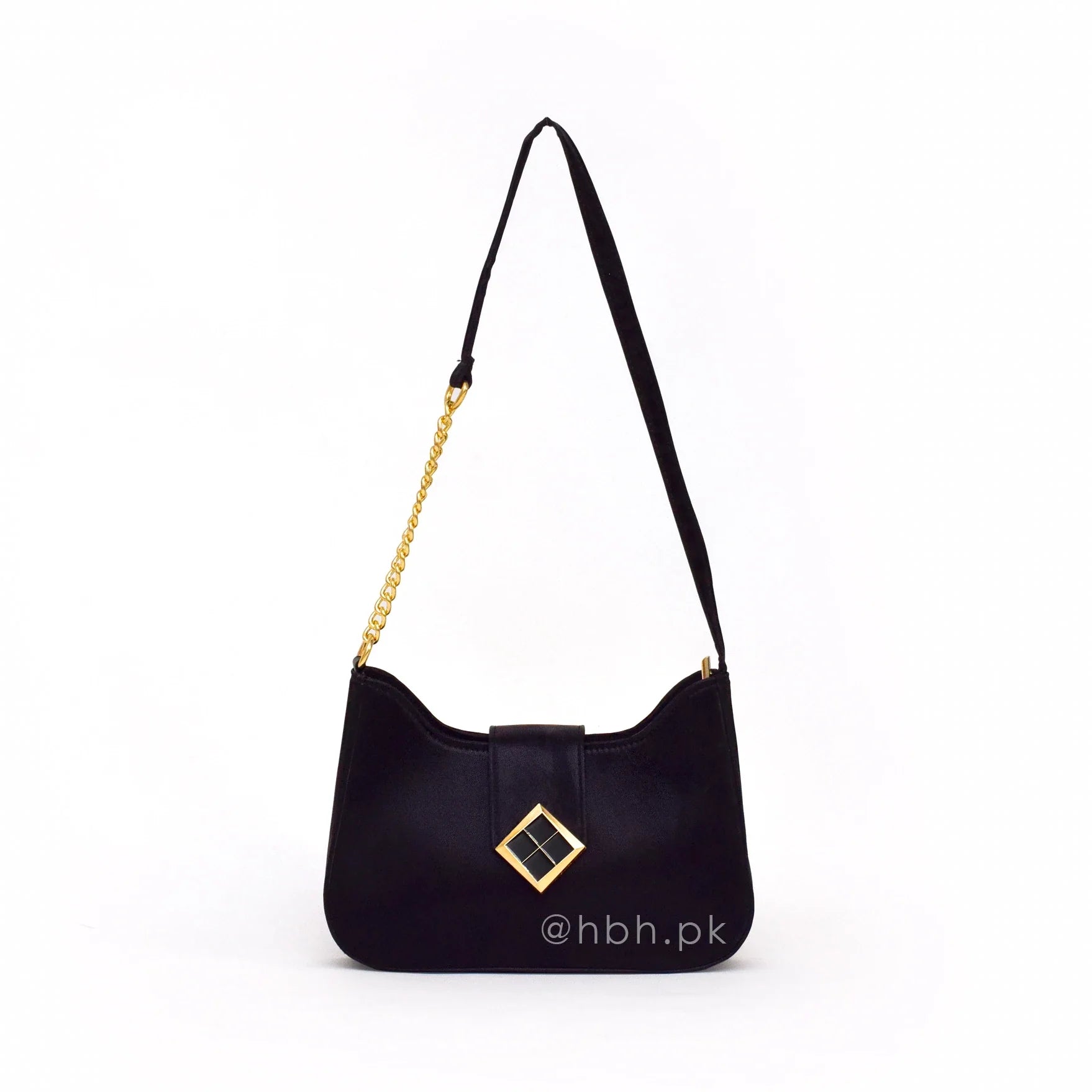 Black handbag with gold chain strap and decorative emblem on a white background
