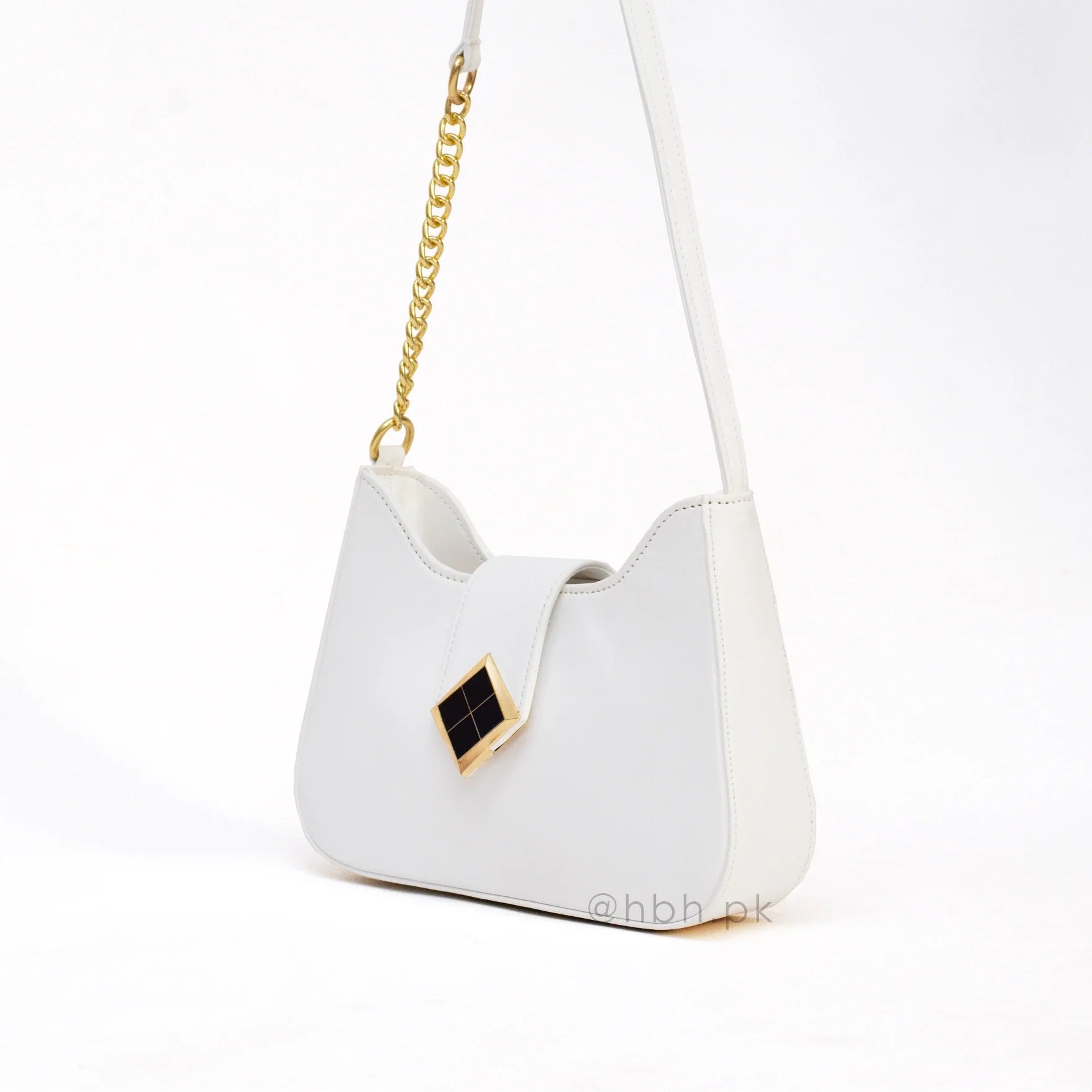 White handbag with gold chain and geometric design on a white background