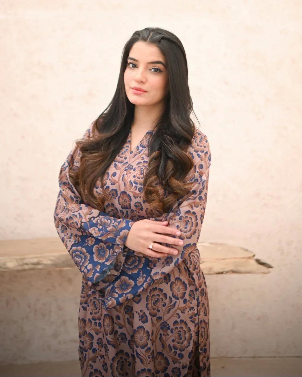 A Women wearing a printed brown and navy blue color two piece dress . Print is floral.