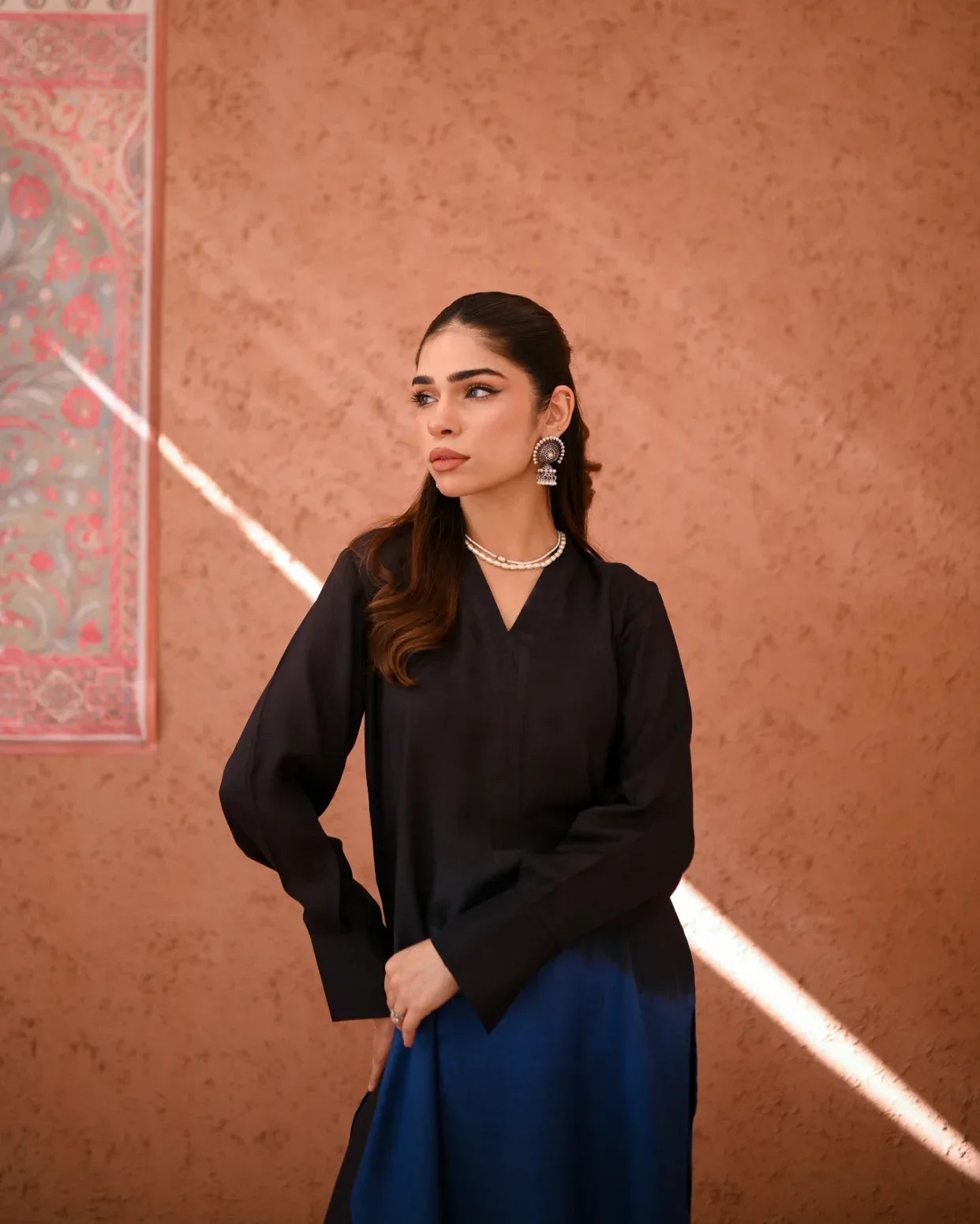 A woman wearing a Rawsilk Ombre shirt, standing in a room with earthen tones.
