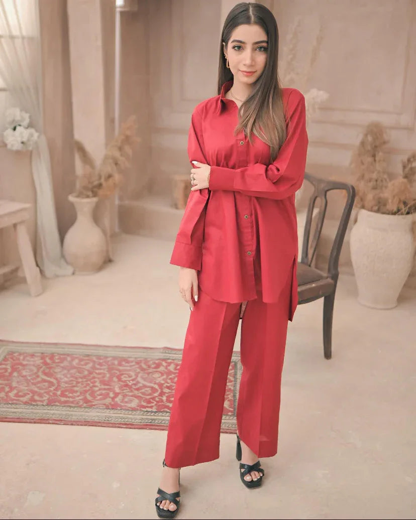 A woman in red dress stands confidently in a well-lit room, surrounded by neutral-colored walls and furniture.