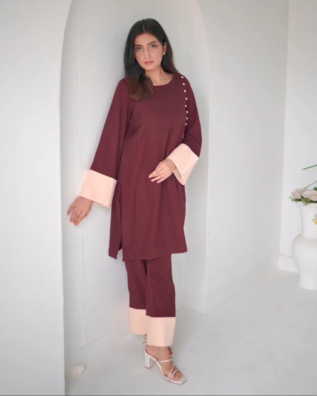 Women wearing a maroon two piece dress with phone color borders on sleeves and trousers.