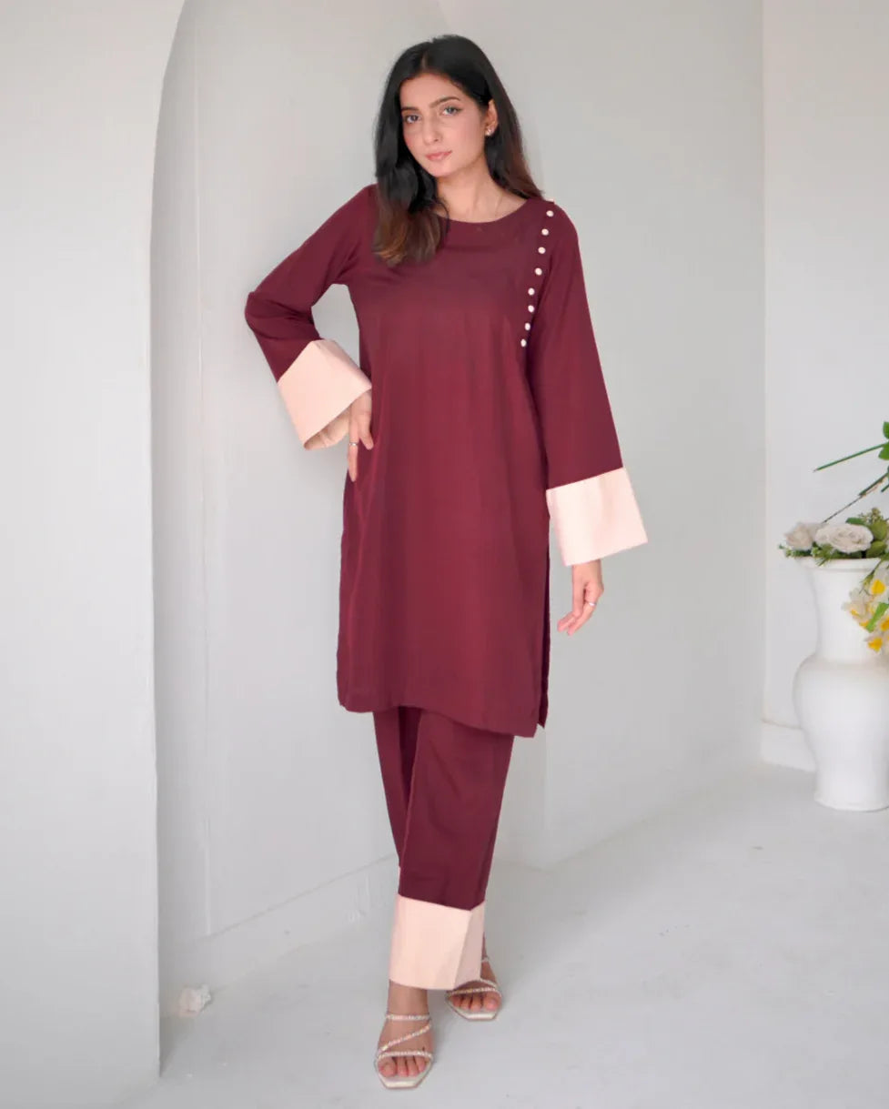 Women wearing a maroon two piece dress with phone color borders on sleeves and trousers.