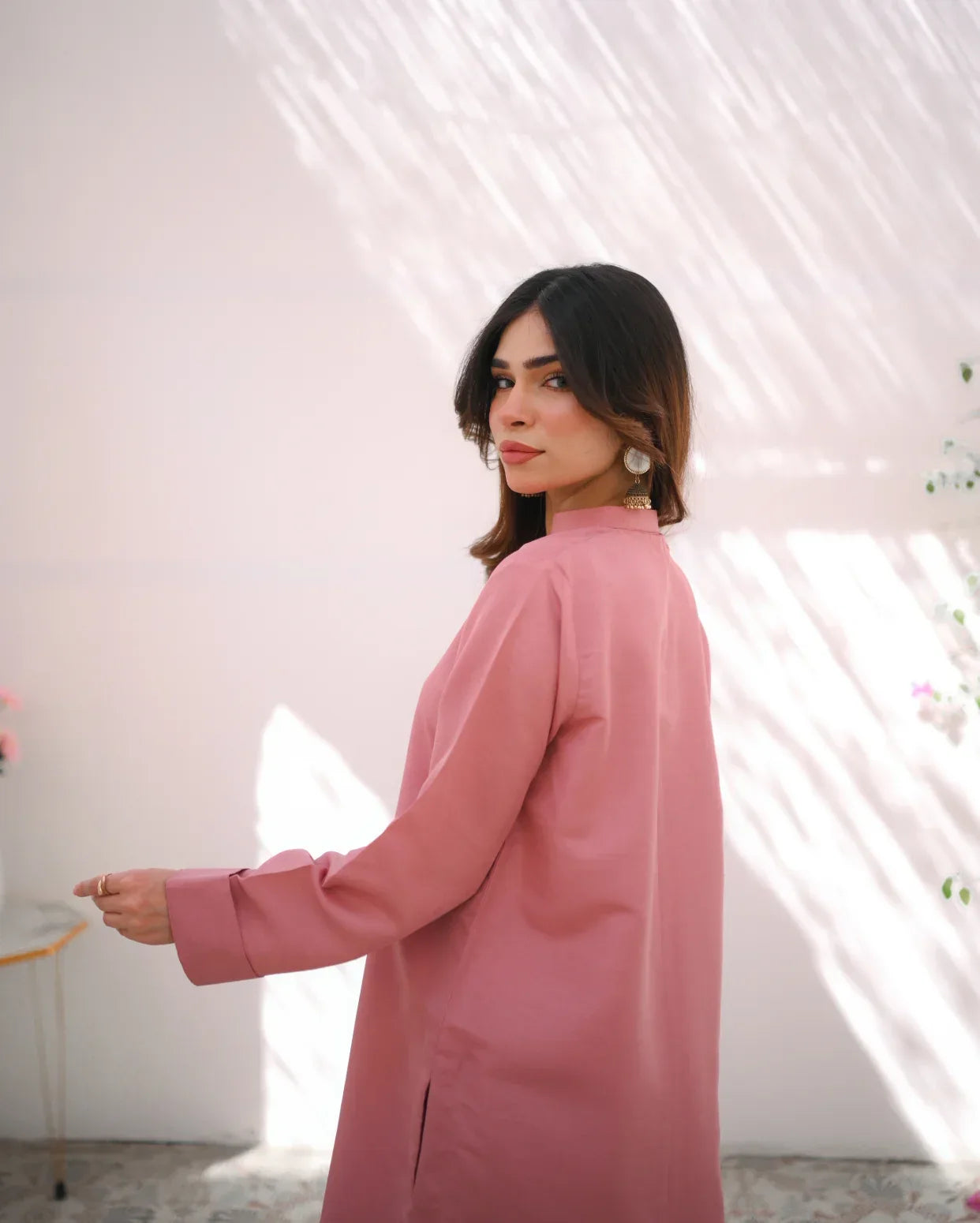 A woman wearing a pink indian rawsilk fabric shirt.