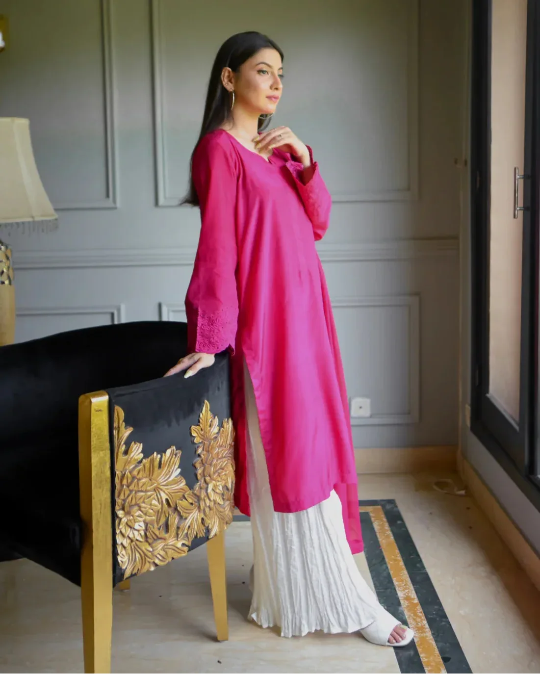 Women wearing a three piece pink color dress which includes a shirt with embroidery on sleeves, dhaka lehenga and a chiffon dupatta.